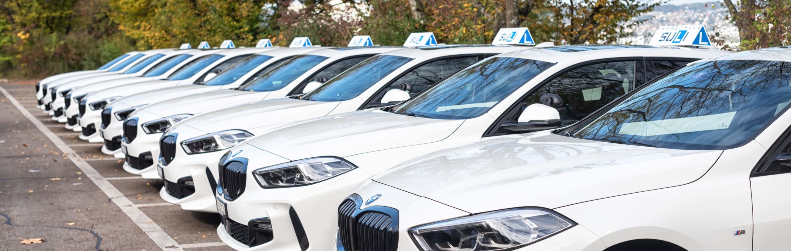 Moderne BMW-Fahrzeuge der Fahrschule Suli stehen nebeneinander – bereit für die nächste Fahrlektion.