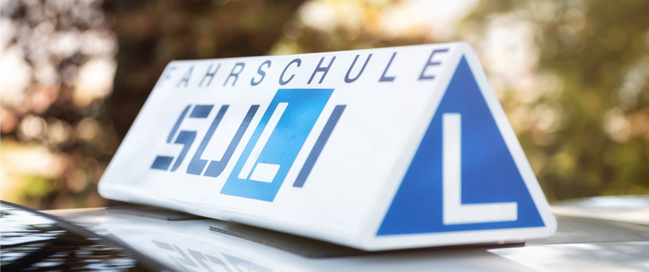 Fahrschulauto mit dem Fokus auf dem 'L' für Lernfahrer.