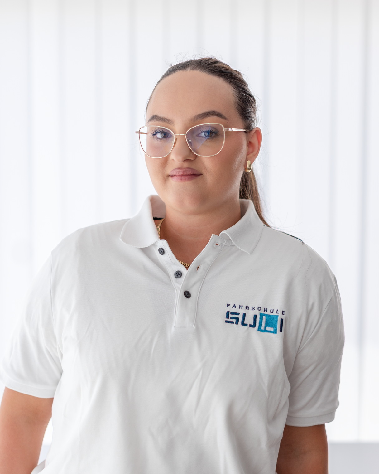 Vlera, Mitarbeiterin im Administrationsteam der Fahrschule Suli, lächelt freundlich am Arbeitsplatz.