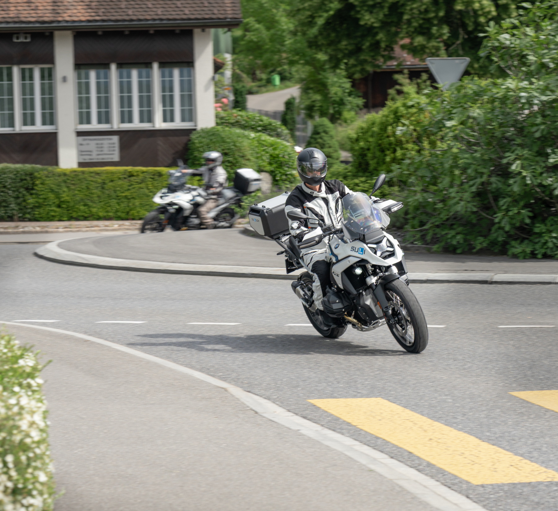 Motorrad-Fahrschüler und Fahrlehrer üben das sichere Befahren eines Kreisverkehrs.