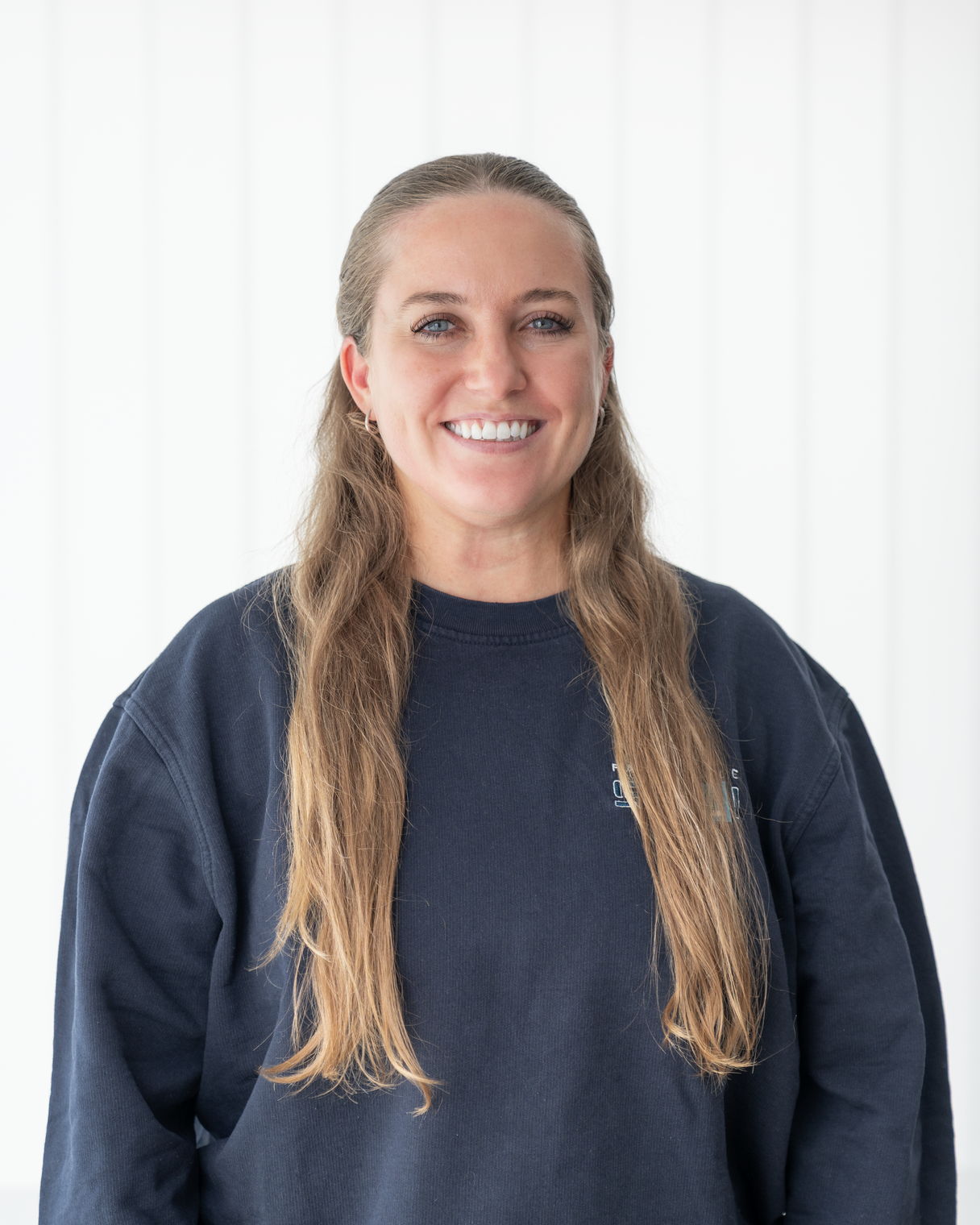 Corinne, Projektleiterin der Fahrschule SULI, lächelt in die Kamera vor dem Logo der Fahrschule.